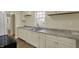 Bright kitchen showcasing granite countertops, white cabinets, and stainless steel sink at 4632 Normal Ave, Indianapolis, IN 46226