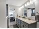 Double vanity bathroom with gray cabinets, a large mirror, and a view of the bedroom at 6559 Seabiscuit Rd, Whitestown, IN 46075