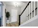 Elegant entryway with a white door, staircase, and a large plant at 6559 Seabiscuit Rd, Whitestown, IN 46075