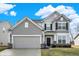 Two-story house featuring gray siding, a black door, and a two-car garage at 6559 Seabiscuit Rd, Whitestown, IN 46075