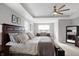 Bright main bedroom with a king-size bed, sitting area, and large window at 6559 Seabiscuit Rd, Whitestown, IN 46075