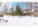 Backyard exterior view of the home surrounded by trees and covered in fresh snow at 9519 Summer Ridge Pl, Indianapolis, IN 46260