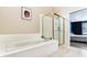 Bright primary bathroom showcasing a soaking tub and glass enclosed shower at 9519 Summer Ridge Pl, Indianapolis, IN 46260