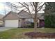 Charming brick home featuring an attached garage, well-maintained lawn, and inviting pink front door at 9519 Summer Ridge Pl, Indianapolis, IN 46260