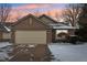 Charming brick home featuring a spacious garage and inviting curb appeal, set against a colorful sunset sky at 9519 Summer Ridge Pl, Indianapolis, IN 46260