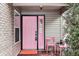 Inviting front porch featuring a pink front door, matching chairs, and stylish accents at 9519 Summer Ridge Pl, Indianapolis, IN 46260