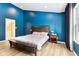 Spacious main bedroom with bright blue walls, dark curtains, and a cozy queen bed at 9519 Summer Ridge Pl, Indianapolis, IN 46260