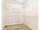 Spacious walk-in closet featuring white shelving and wood-look floors for organized storage at 9519 Summer Ridge Pl, Indianapolis, IN 46260