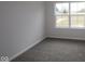 This bedroom features neutral walls, plush carpet, and a large window with natural light at 1144 Ridgevine Rd, Greenwood, IN 46143