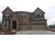 Stunning two-story brick home with a three-car garage and covered entryway, presenting an inviting curb appeal at 1144 Ridgevine Rd, Greenwood, IN 46143