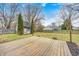 Backyard with a deck and shed surrounded by a fenced yard with mature trees and blue sky at 12301 Van Spronsen Ct, Indianapolis, IN 46236