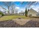 A landscaped backyard has a fire pit and large grassy area surrounded by mature trees at 12301 Van Spronsen Ct, Indianapolis, IN 46236
