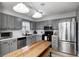 Well-lit kitchen featuring gray cabinets, modern appliances, white subway tile backsplash, and an island table at 12301 Van Spronsen Ct, Indianapolis, IN 46236