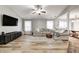 Open-concept living room with wood floors, a plush sofa, large windows, and a mounted TV at 12301 Van Spronsen Ct, Indianapolis, IN 46236