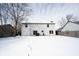 View of backyard with a snow-covered lawn and two-story home with sliding glass door at 12643 Feldspar Rd, Indianapolis, IN 46236