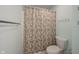 Cozy bathroom featuring a floral shower curtain, towel bar, and white toilet at 12643 Feldspar Rd, Indianapolis, IN 46236