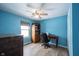 Bedroom with blue walls, ceiling fan, desk, and a wooden dresser at 12643 Feldspar Rd, Indianapolis, IN 46236