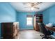 Bedroom with blue walls, ceiling fan, desk, and a wooden dresser at 12643 Feldspar Rd, Indianapolis, IN 46236