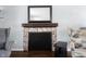 Close up of a fireplace with detailed tile surround, dark mantle and hardwood floors at 12643 Feldspar Rd, Indianapolis, IN 46236