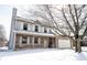 Charming two-story home featuring a cozy front porch and an attached garage, set in a snowy landscape at 12643 Feldspar Rd, Indianapolis, IN 46236