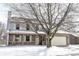 Charming two-story home featuring a cozy front porch and an attached garage partially obscured by a leafless tree at 12643 Feldspar Rd, Indianapolis, IN 46236