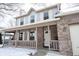 Inviting front porch with brick accents and a porch swing, leading to the front door during winter at 12643 Feldspar Rd, Indianapolis, IN 46236