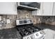 Modern kitchen featuring stainless steel appliances, mosaic backsplash, and granite countertops at 12643 Feldspar Rd, Indianapolis, IN 46236