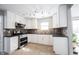 Modern kitchen featuring white cabinets, stainless steel appliances, and stylish backsplash at 12643 Feldspar Rd, Indianapolis, IN 46236