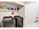 A clean and functional laundry room with modern appliances and shelving for storage at 1442 Northbrook Dr, Indianapolis, IN 46260