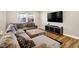Cozy living room featuring a large sectional sofa, TV, and wood flooring at 1442 Northbrook Dr, Indianapolis, IN 46260
