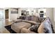 Open living room featuring a large sectional sofa and a view of the modern kitchen at 1442 Northbrook Dr, Indianapolis, IN 46260
