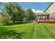 A lush, green backyard features a well-kept lawn and a screened porch with a wood deck at 18725 Wychwood Pl, Noblesville, IN 46062