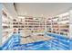 Finished basement with blue epoxy floors, white built-in shelving and comfortable seating for entertaining and relaxation at 18725 Wychwood Pl, Noblesville, IN 46062