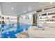 Finished basement with blue epoxy floors, white built-in shelving and comfortable seating with easy access to staircase at 18725 Wychwood Pl, Noblesville, IN 46062