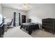 Bedroom featuring neutral carpet, ceiling fan, and large window with blue curtains at 18725 Wychwood Pl, Noblesville, IN 46062