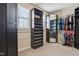 Well-organized walk-in closet with dark shelving, hanging rods, and a mirrored cabinet at 18725 Wychwood Pl, Noblesville, IN 46062