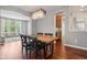Dining room with views to the kitchen and living room, with table with seating for six and modern chandelier at 18725 Wychwood Pl, Noblesville, IN 46062