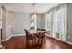 Dining room with wood floors, table with seating for six, modern chandelier, and lots of natural light at 18725 Wychwood Pl, Noblesville, IN 46062