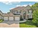 Beautiful two-story home with a stone and siding facade and a three-car garage at 18725 Wychwood Pl, Noblesville, IN 46062