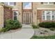 Elegant front entrance with a stone facade, manicured bushes, and a pathway at 18725 Wychwood Pl, Noblesville, IN 46062