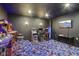 Retro game room equipped with arcade machines, stools, and vibrant carpeting for entertainment at 18725 Wychwood Pl, Noblesville, IN 46062