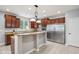 Kitchen with cherry cabinets, granite countertops, tile floor, and stainless steel appliances, perfect for modern cooking at 18725 Wychwood Pl, Noblesville, IN 46062