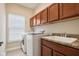 Laundry room featuring a sink, washer, dryer, and storage cabinets at 18725 Wychwood Pl, Noblesville, IN 46062