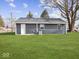 Rear view of the house showcasing a dark blue exterior and grassy backyard at 403 Wellington Blvd, Shelbyville, IN 46176