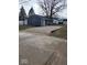 View of the home's exterior featuring gravel driveway, updated siding and new windows at 403 Wellington Blvd, Shelbyville, IN 46176