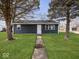 Newly built home with a dark blue exterior, well-manicured lawn, and walkway at 403 Wellington Blvd, Shelbyville, IN 46176