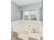 An oversized bathtub sits below a set of bright windows that allow for an open feel in the bathroom at 493 Clearwater Blvd, Whiteland, IN 46184