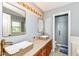A bright bathroom with double sinks, attractive lighting, and tile floor also features access to the shower and bathtub at 493 Clearwater Blvd, Whiteland, IN 46184