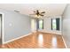 A bedroom with a ceiling fan, laminate flooring, and a view from the double windows to the landscape outside at 493 Clearwater Blvd, Whiteland, IN 46184