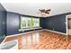 Spacious living room with hardwood floors, ceiling fan, and a large window with backyard views at 493 Clearwater Blvd, Whiteland, IN 46184